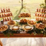 Traditional Polynesian luau feast featuring assorted desserts, pastries, and shared dishes displayed on a tropical buffet table for communal dining