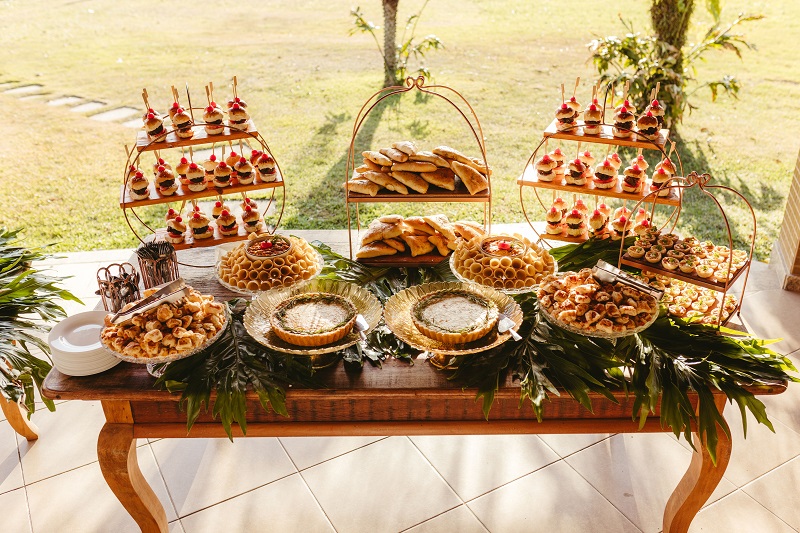 Traditional Polynesian luau feast featuring assorted desserts, pastries, and shared dishes displayed on a tropical buffet table for communal dining
